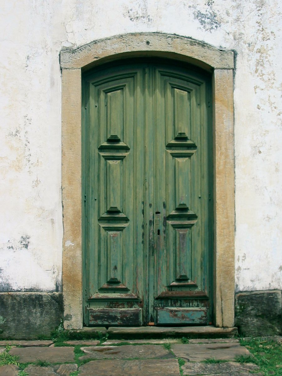 large green double door in front of a white wall