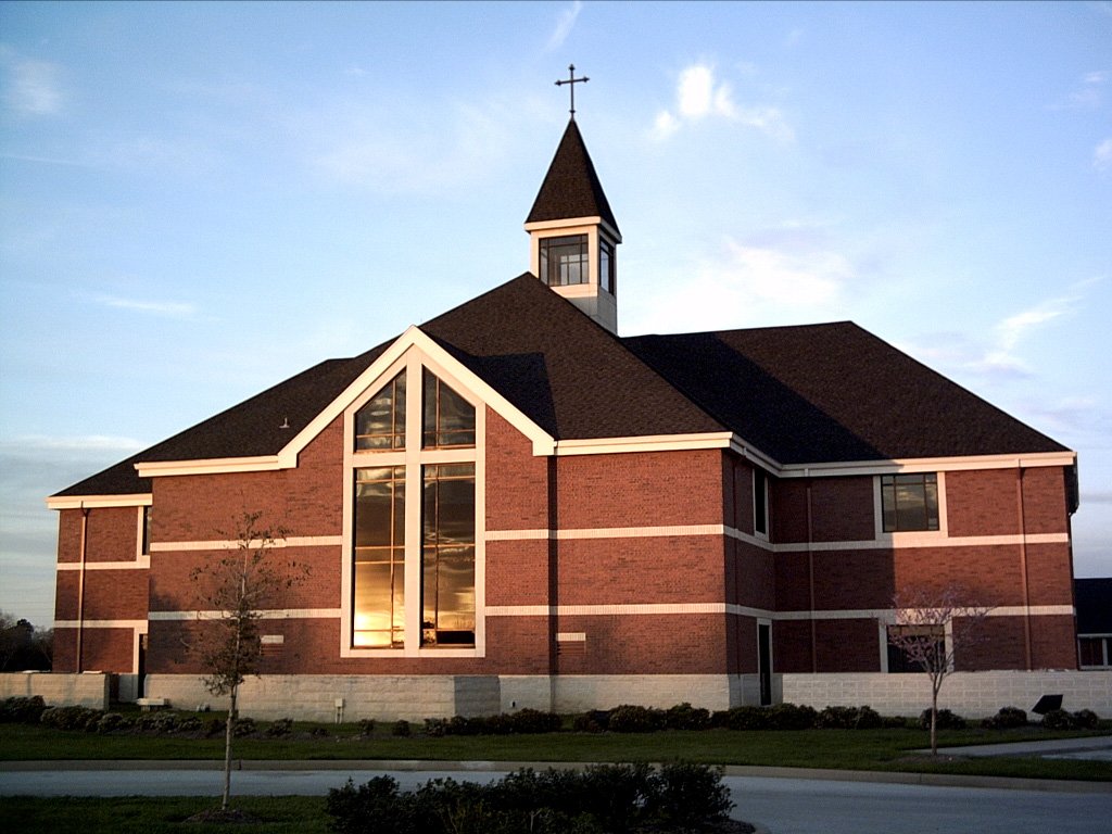 a large red brick church with a cross on top