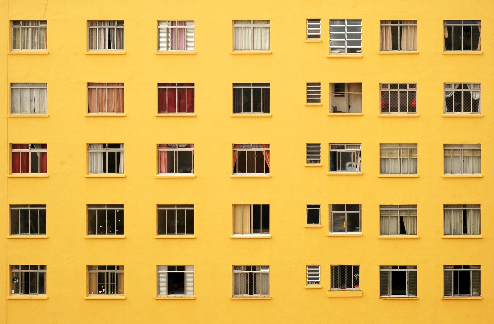 a yellow building is filled with many open windows