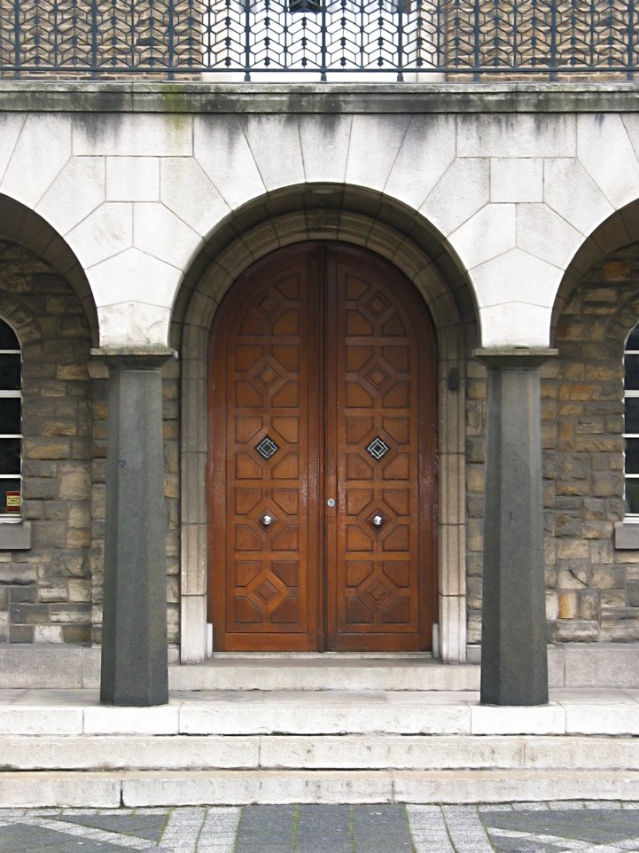 two large wooden doors sitting next to each other on the side of a building