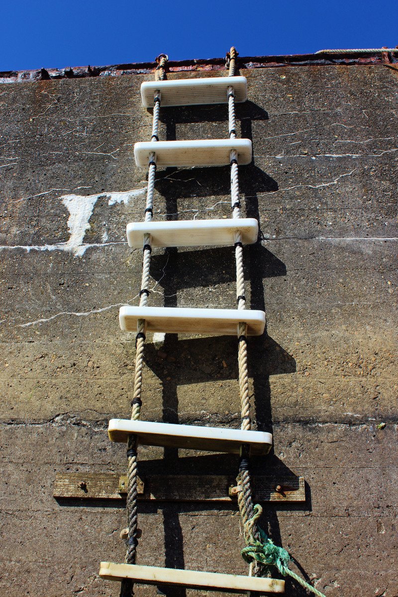 a roped wooden structure is placed on a concrete surface