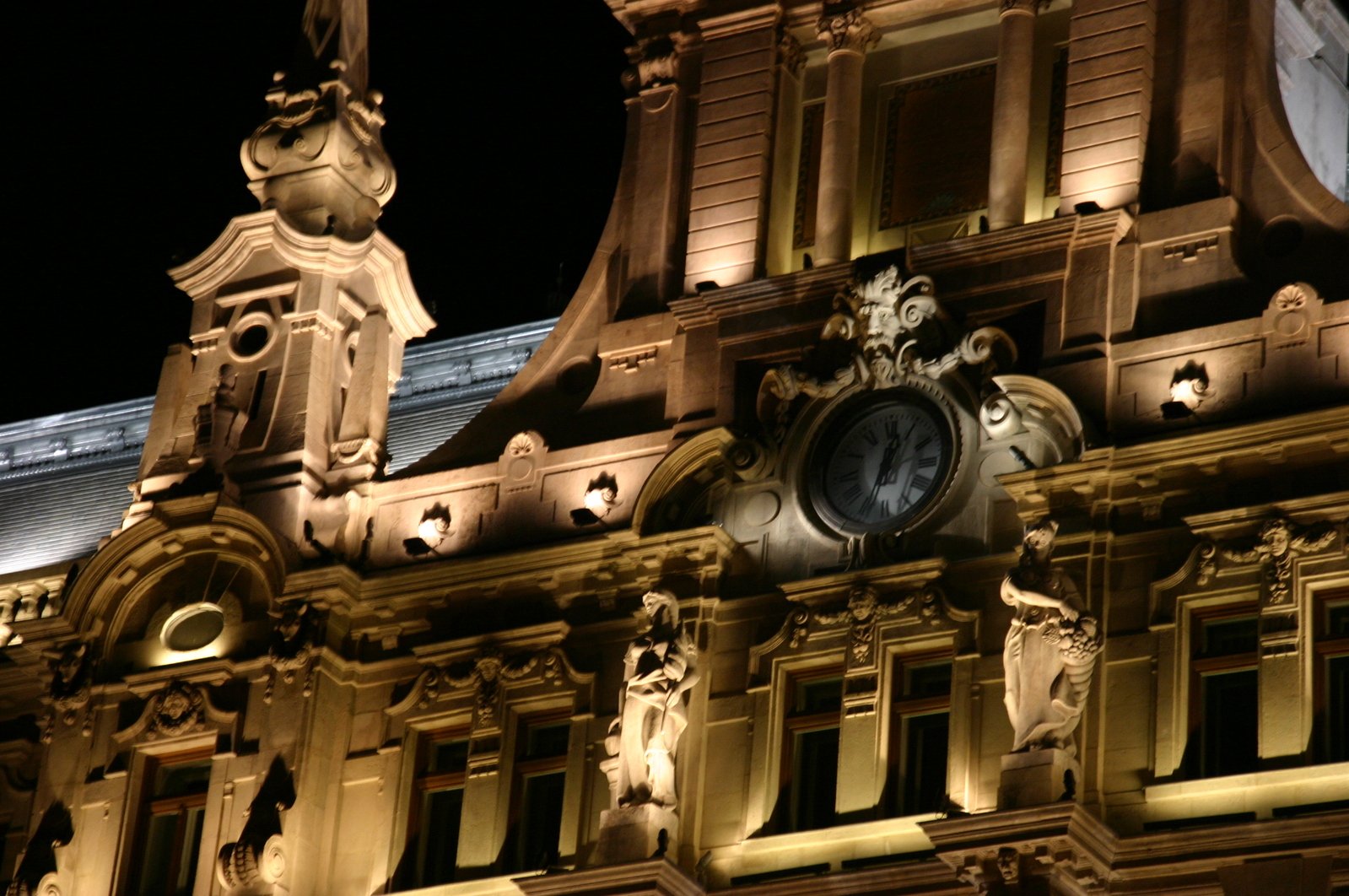 large building with clock in lite at night