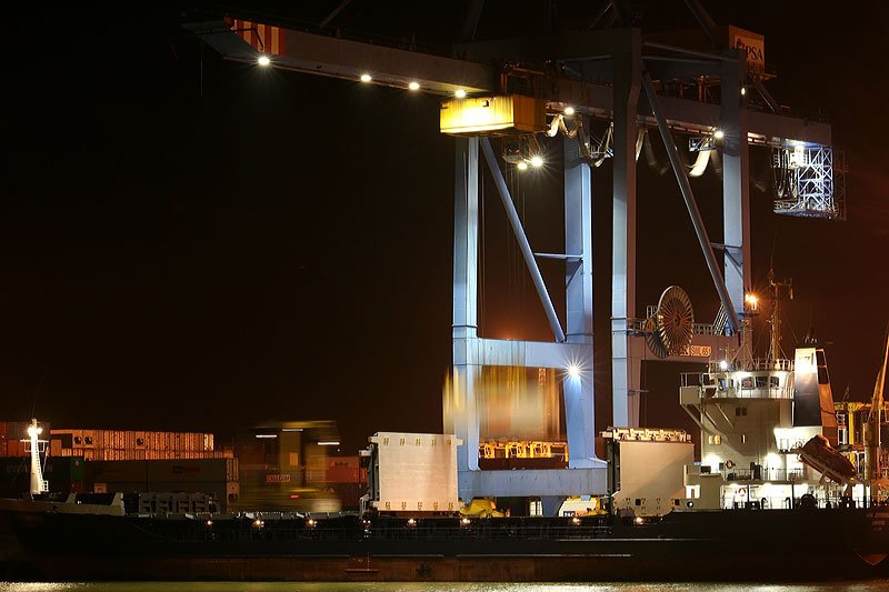 two large cargo ships sit docked in the port