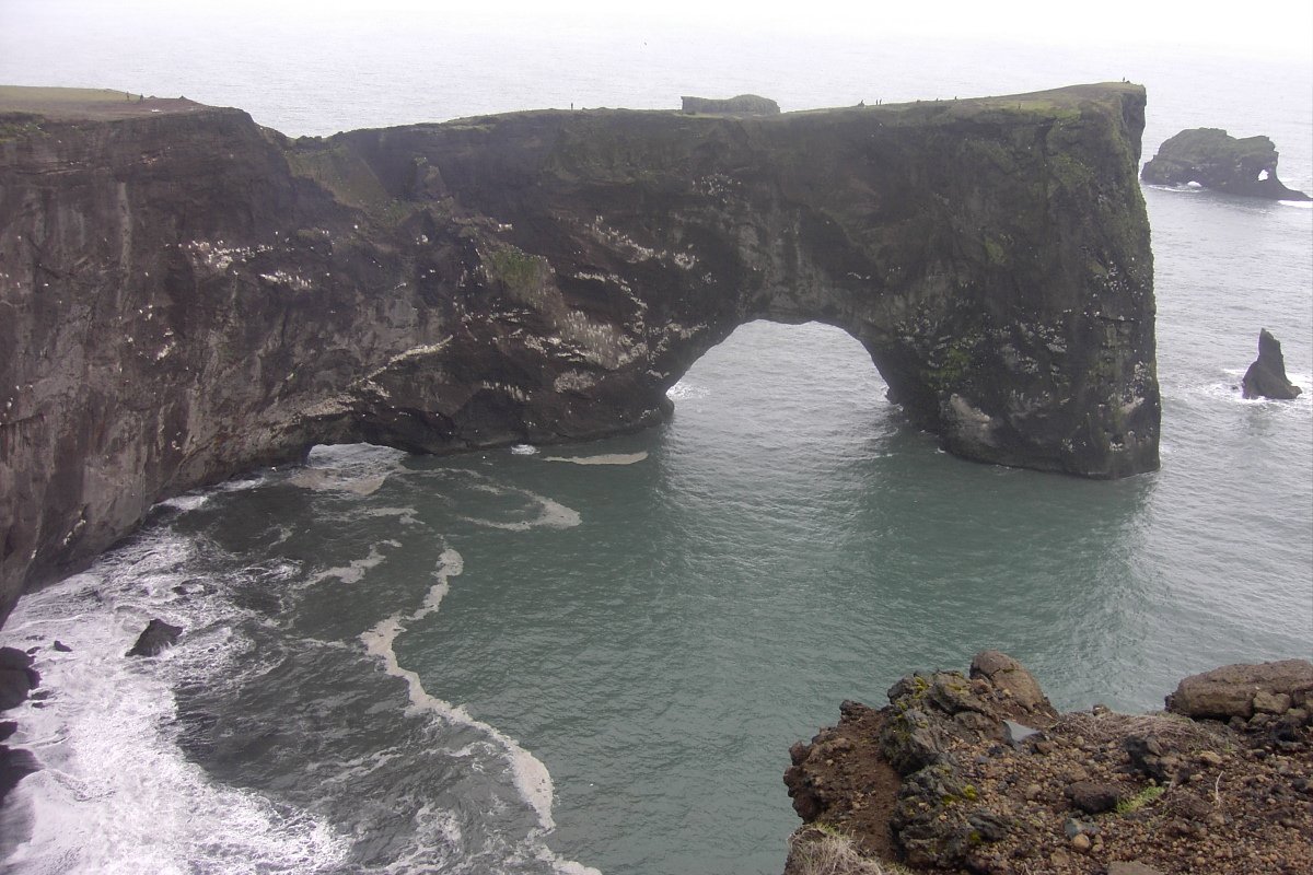 a cliff bridge over the ocean near rocky cliffs