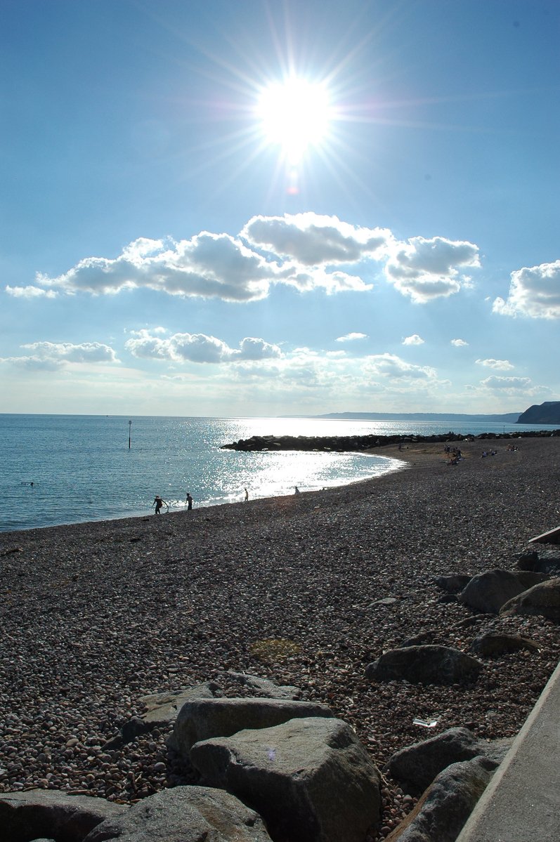 a person is walking on the shore line and the water is calm