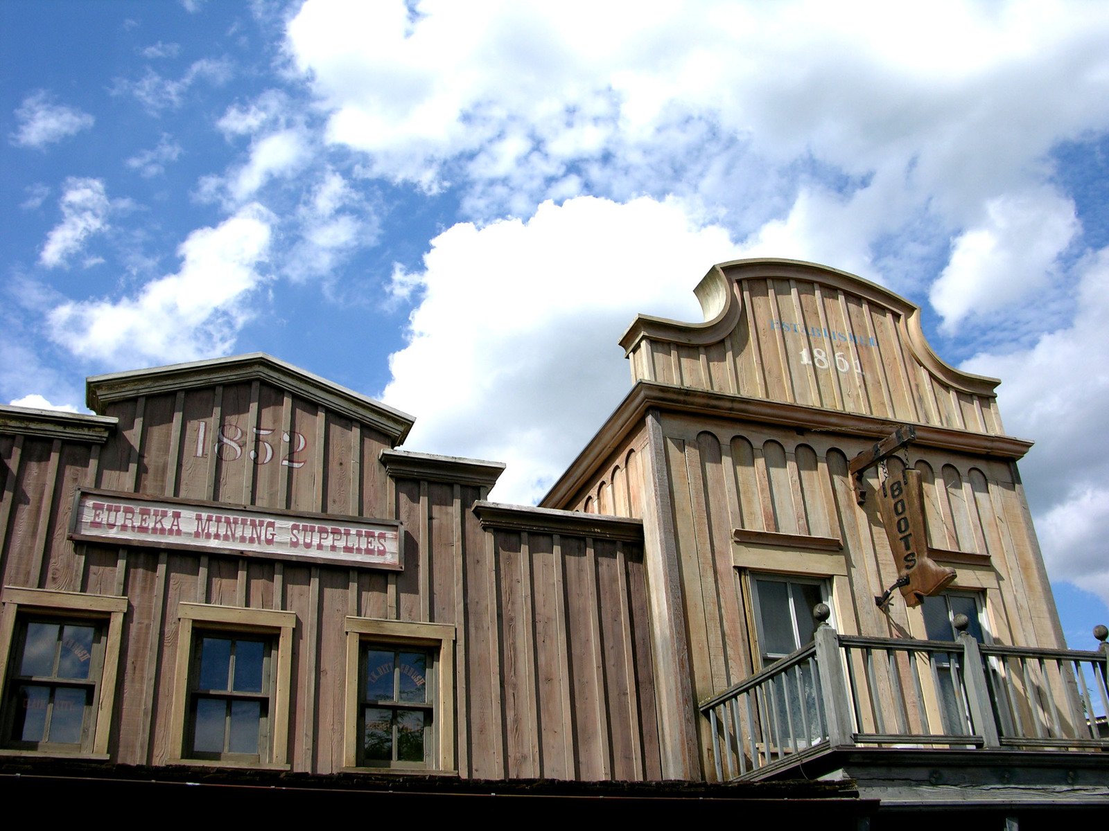 a large wooden building has two clocks on it's side