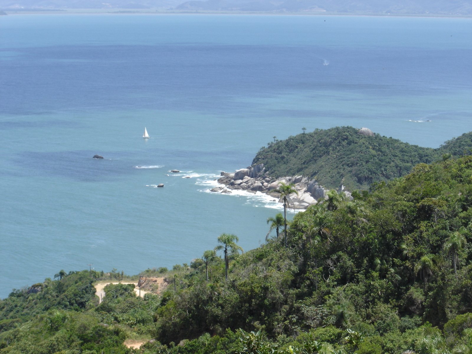 a boat on a lake in the ocean near a beach