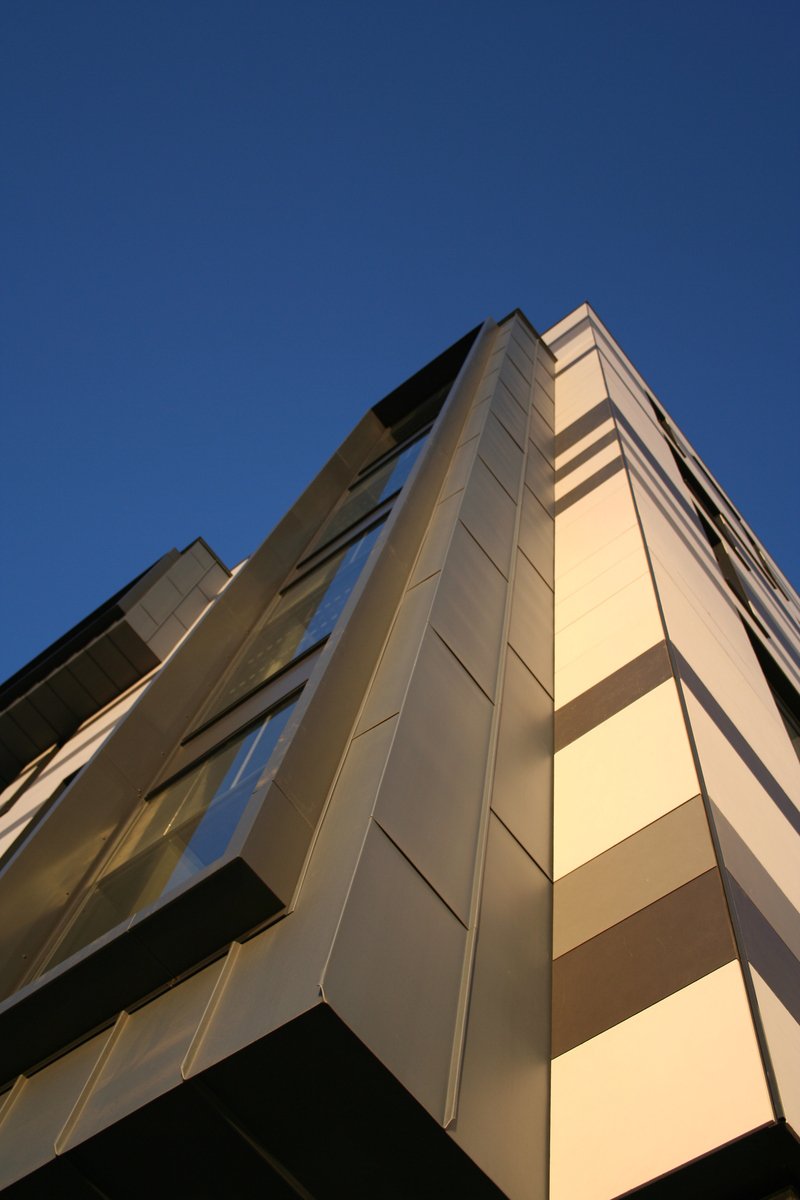 a high rise building with multiple glass windows on top