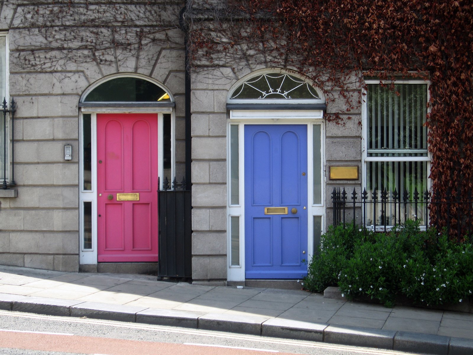 two brightly colored doors outside of a multi - toned building