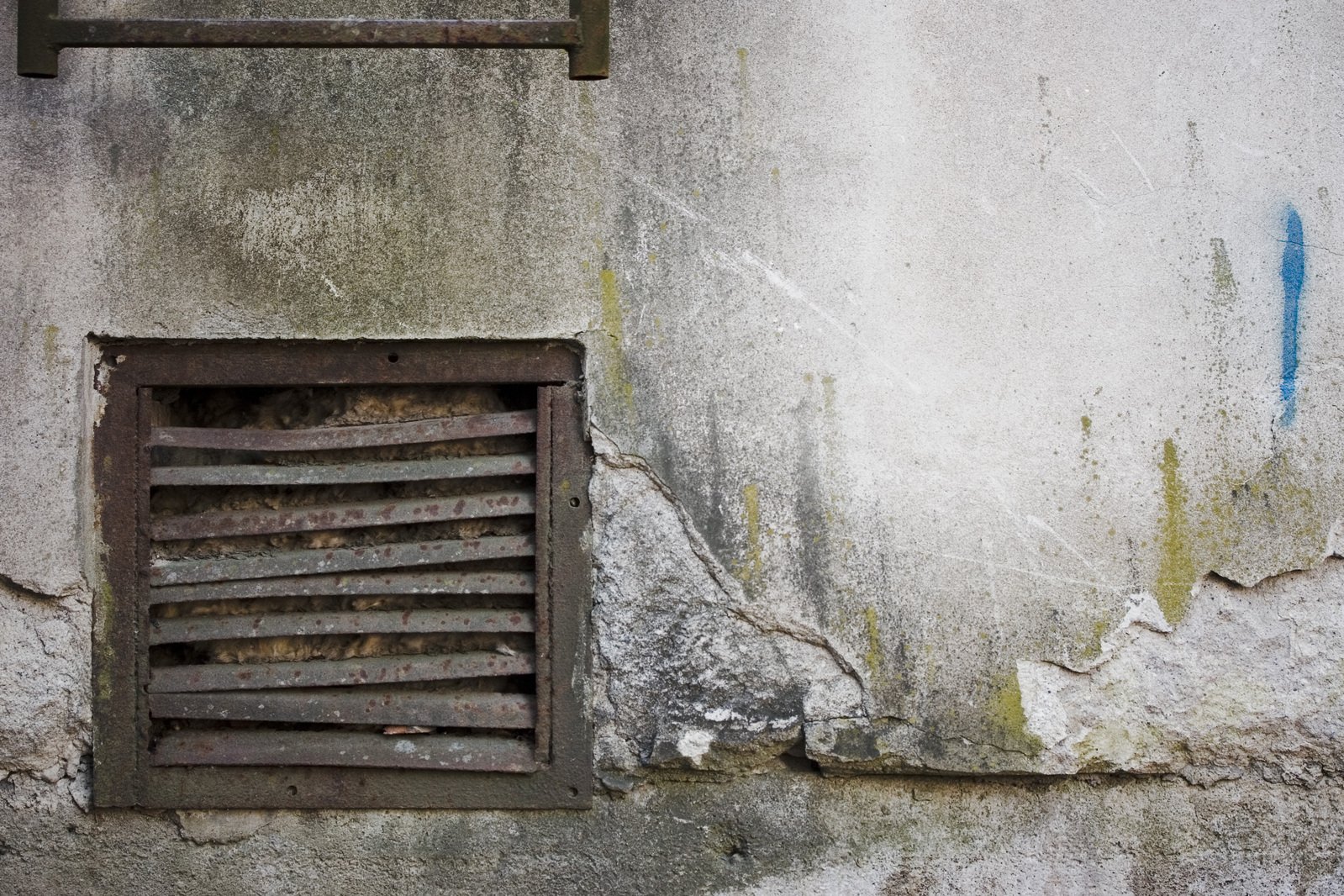 a dirty wall and window next to it