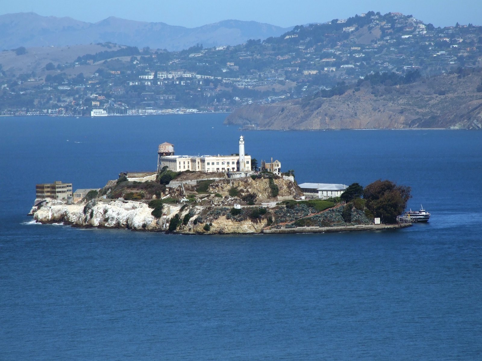 a island in a body of water surrounded by mountains