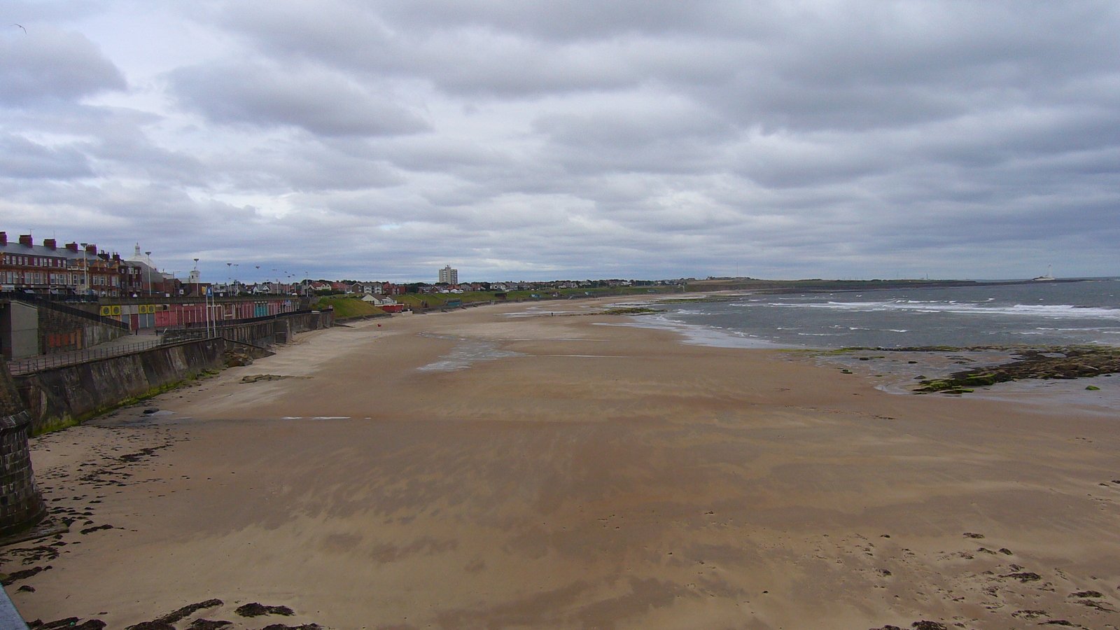 there is a beach in the distance with houses on the sand