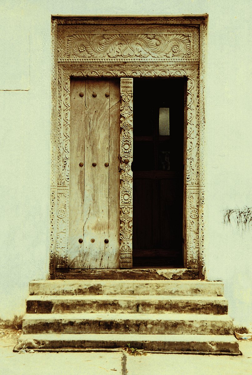 an old wooden door sitting next to a set of stone steps