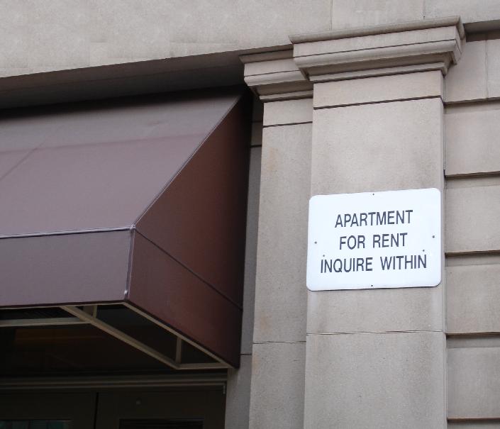 a sign on a building that reads apartment for rent inquire within