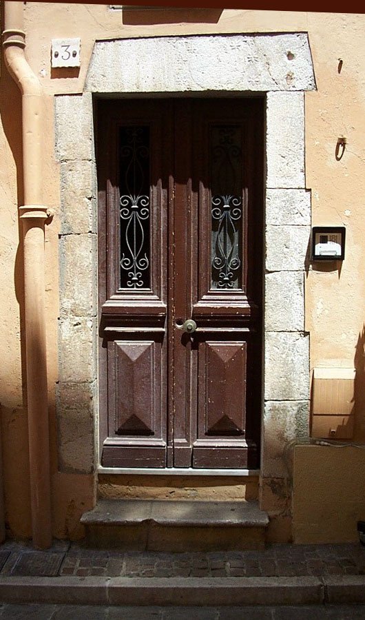 a tall wooden door with a light brown frame