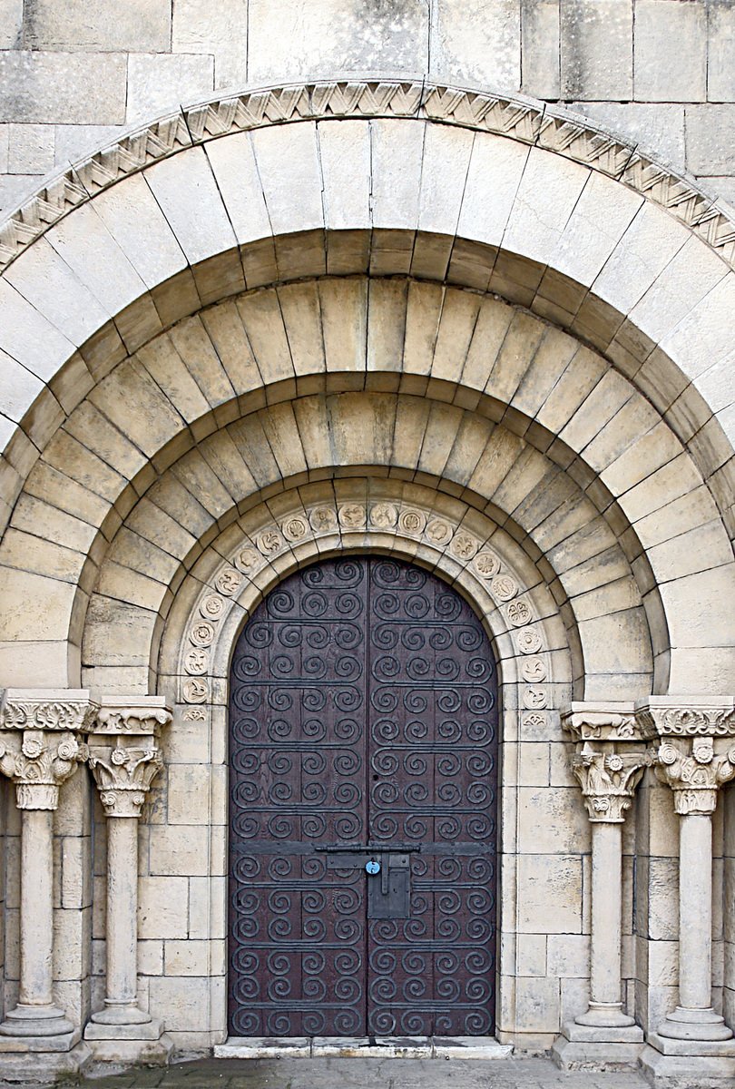 a stone arch has two carved doors