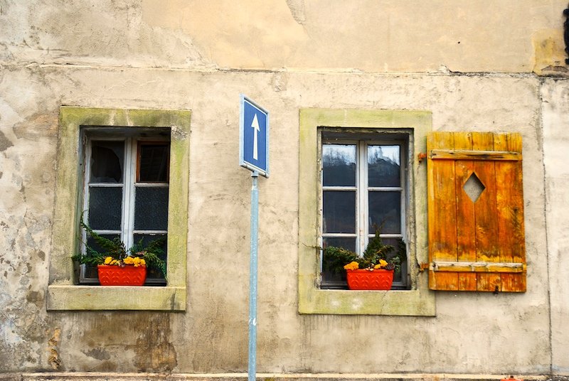 a sign sitting in front of two windows