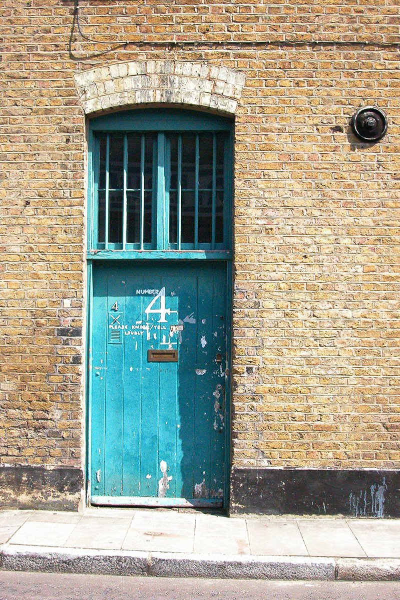 an old door with bars closed on a brick building