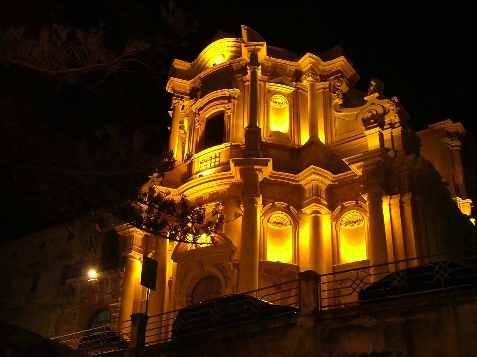 an old building is illuminated at night with street lights
