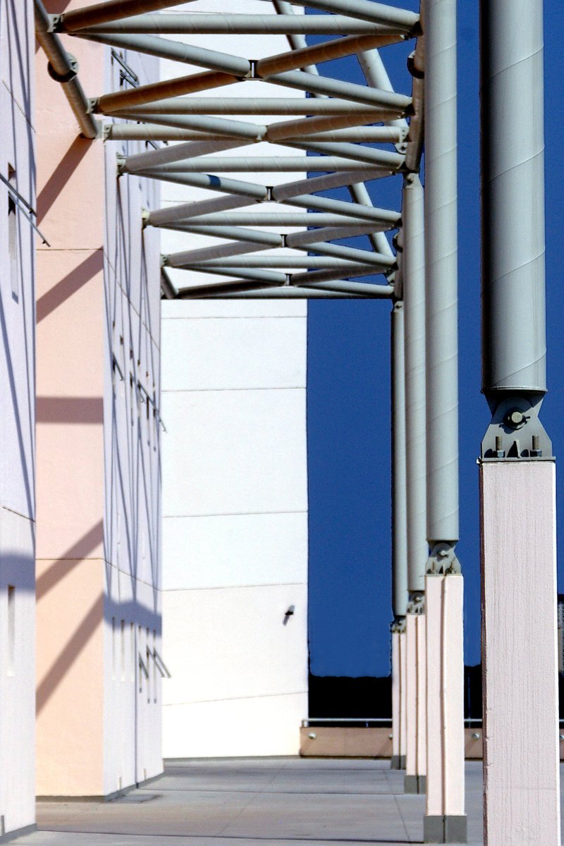 an empty building with a metal roof and white pillars