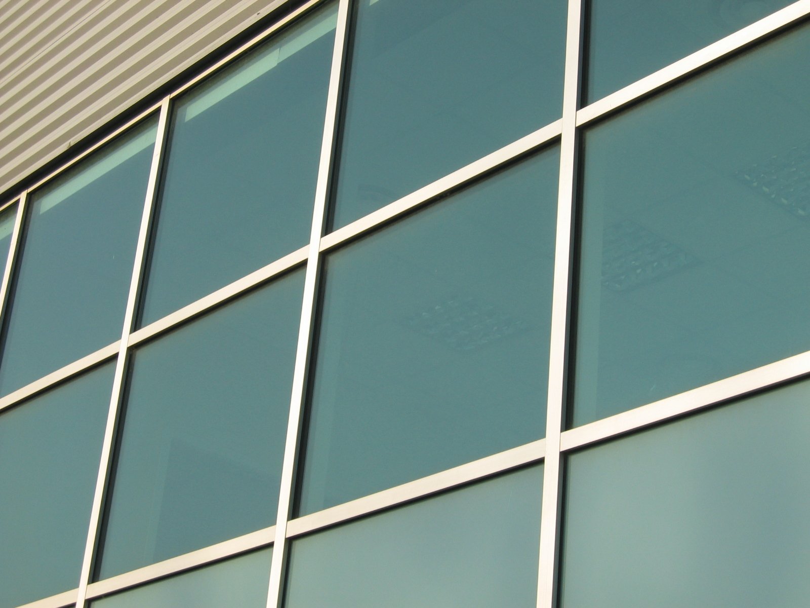 a building with large glass windows and a red clock on the corner