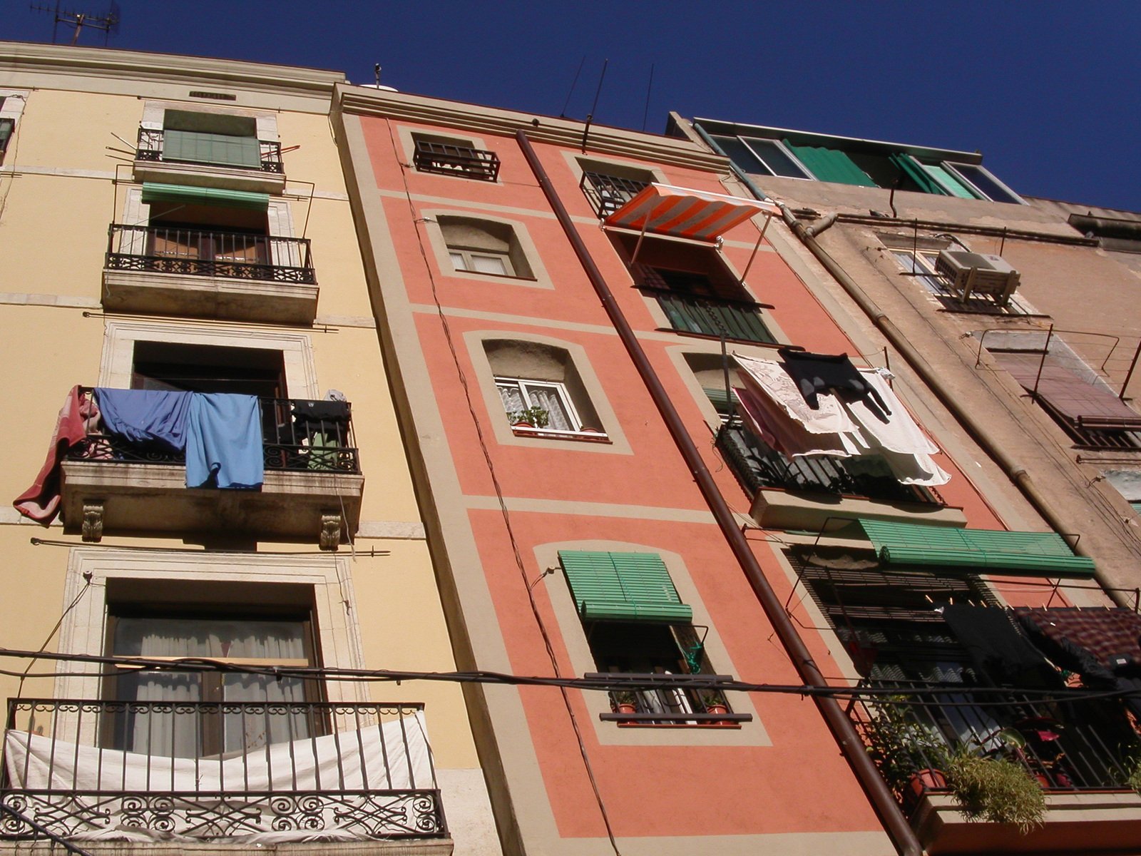 several windows with green shutters on two sides of an old building