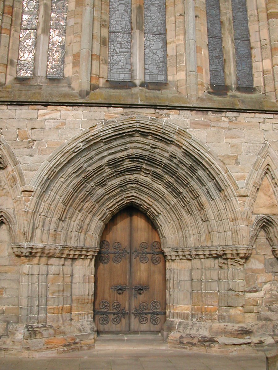 large arched wooden doors on a very tall building