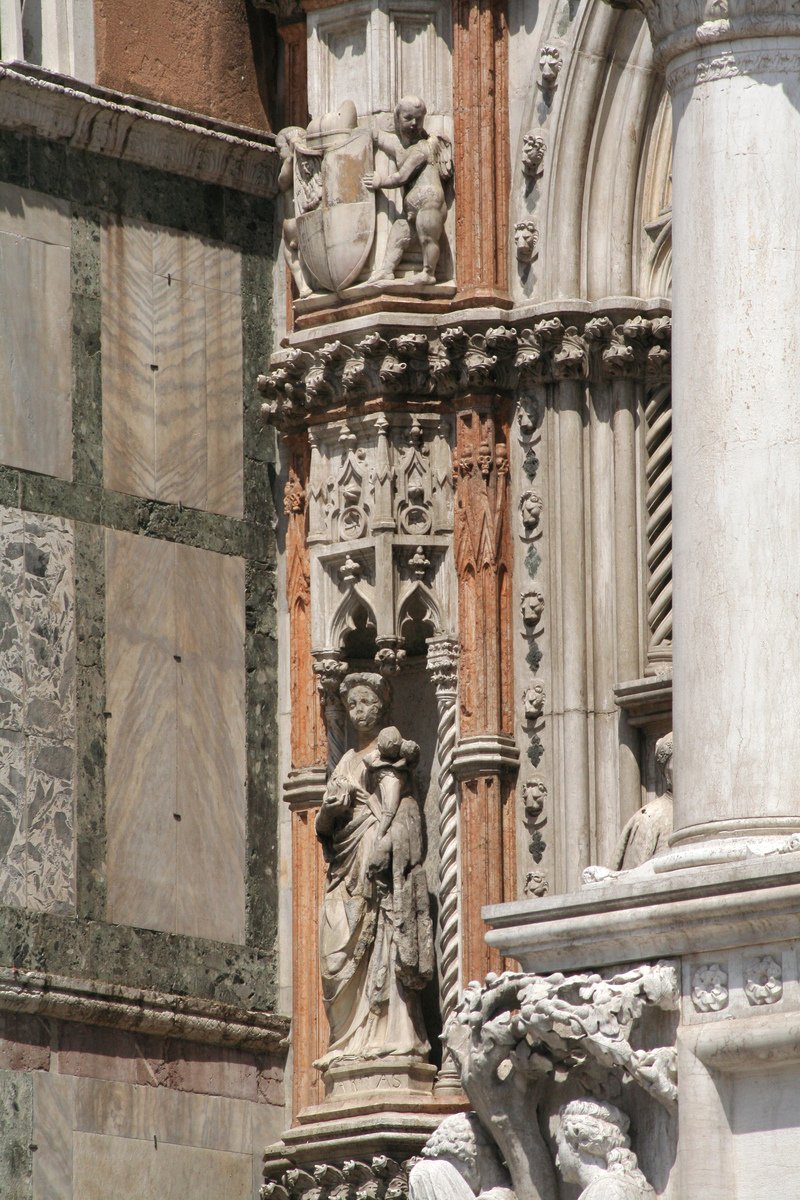statues on a window with old architectural gargoyle