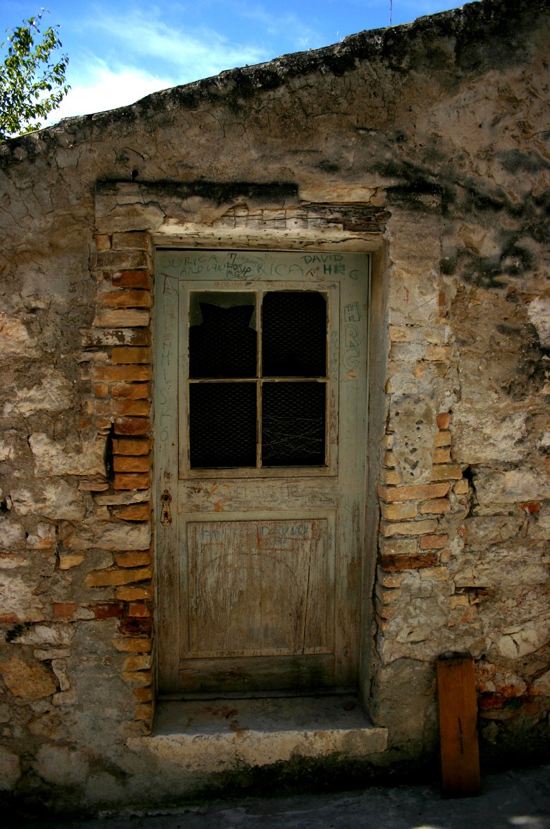an old wooden door outside a stone wall