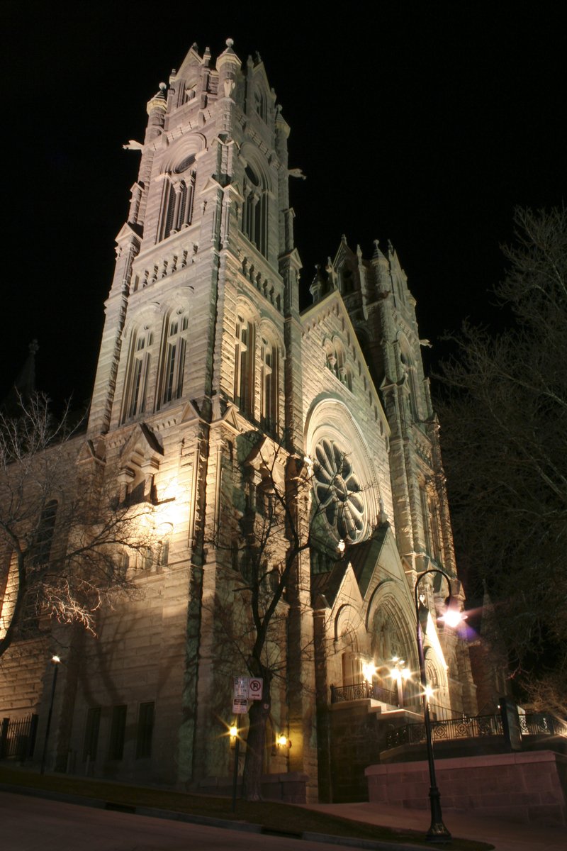 a cathedral lit up at night with a traffic signal