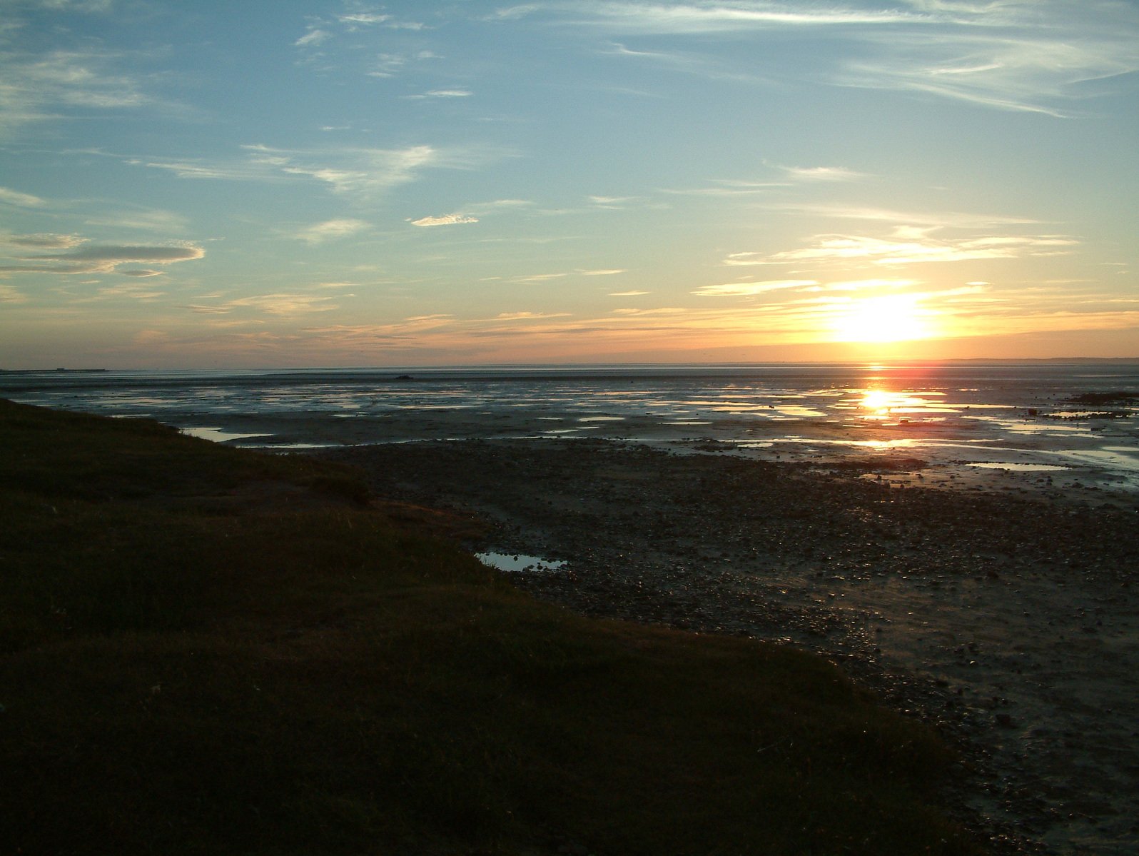 the sun setting over the ocean and land