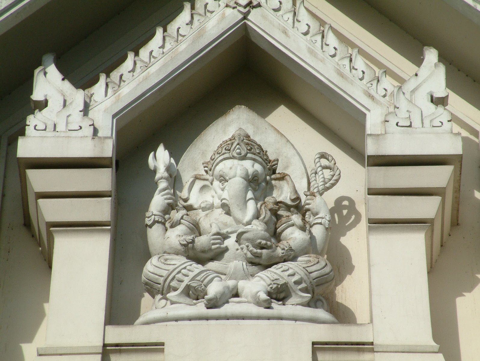a sculpture of ganji sitting on the side of a building