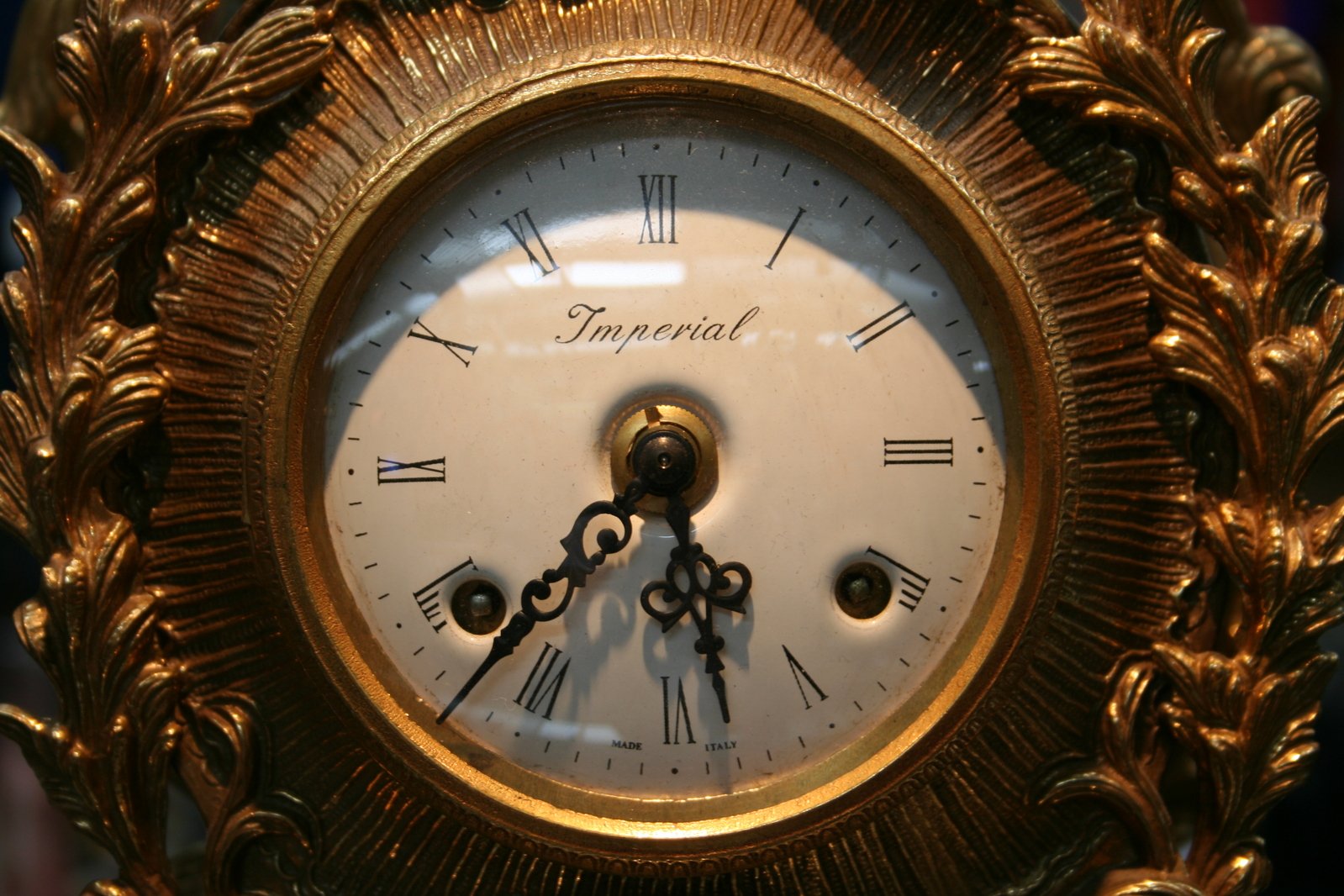 an ornate gold clock with roman numerals inside