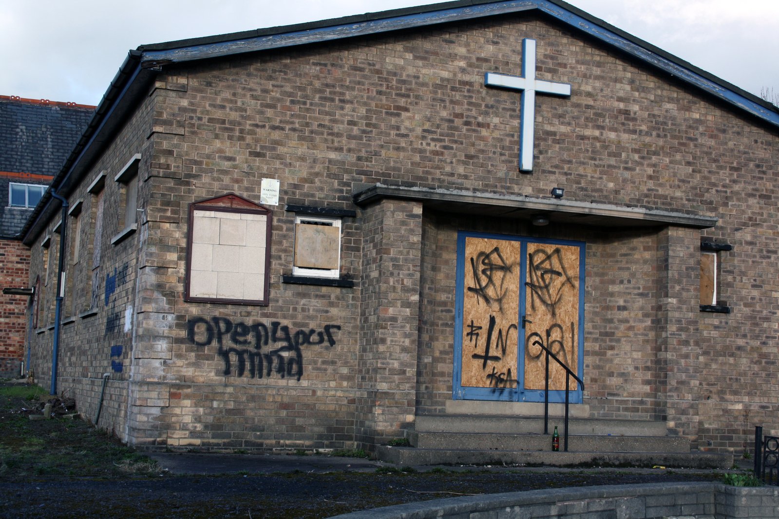 a church with graffiti on it and the door ed