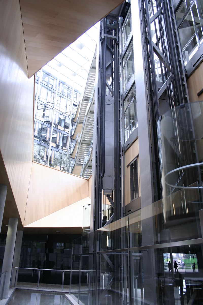 the interior of an office building with large windows and a glass staircase