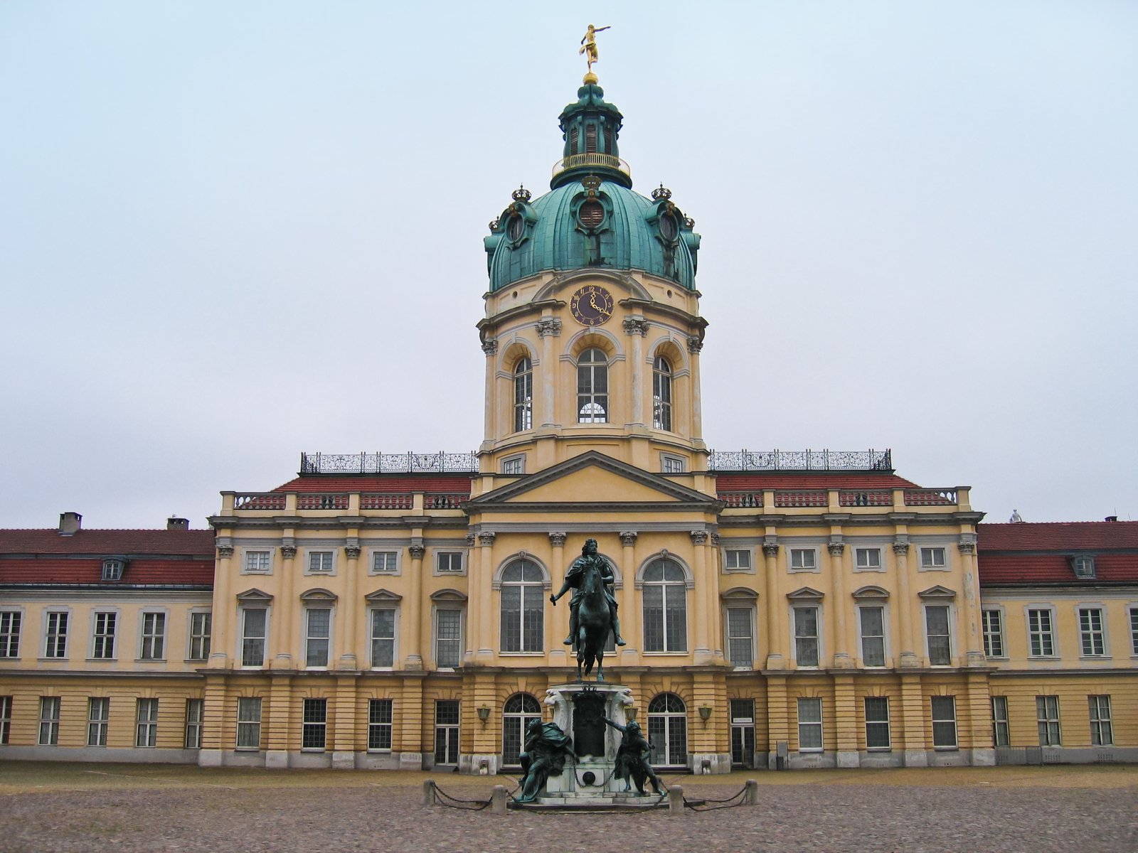 a statue sits in the courtyard next to an ornate building