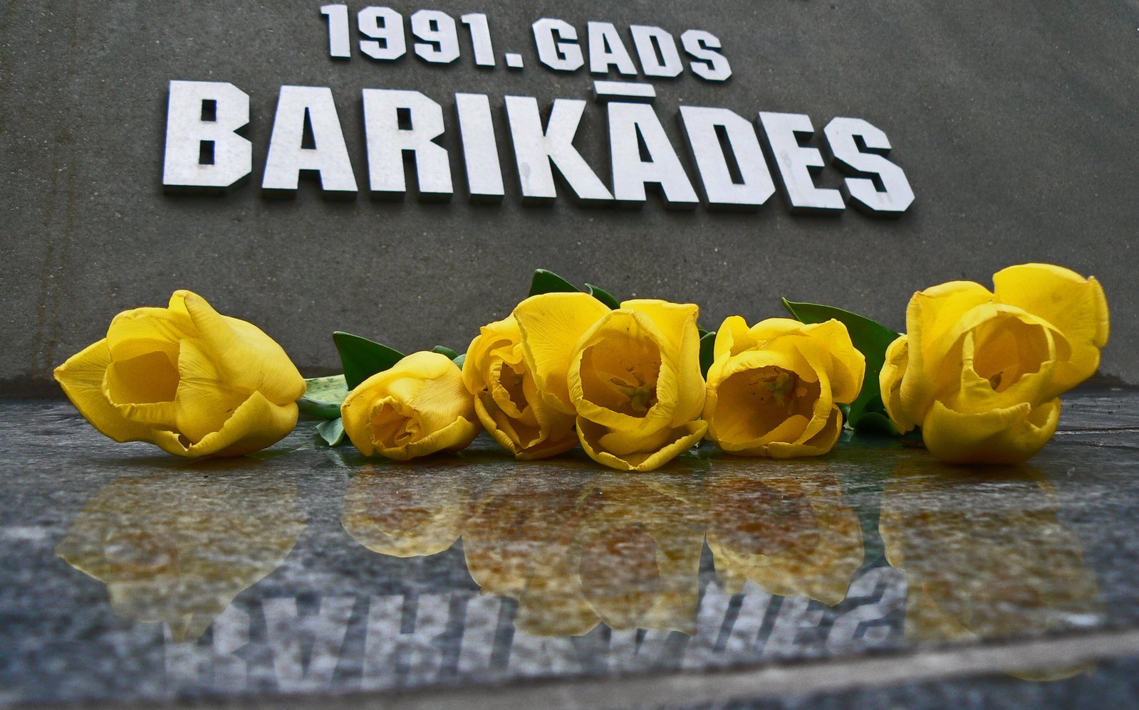 a po of flowers laying on a memorial table