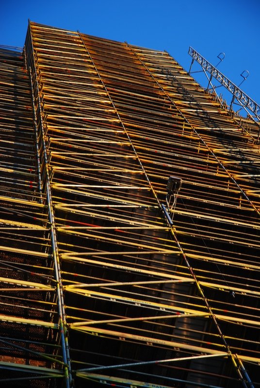 a building has a tall bamboo tower with lights at top