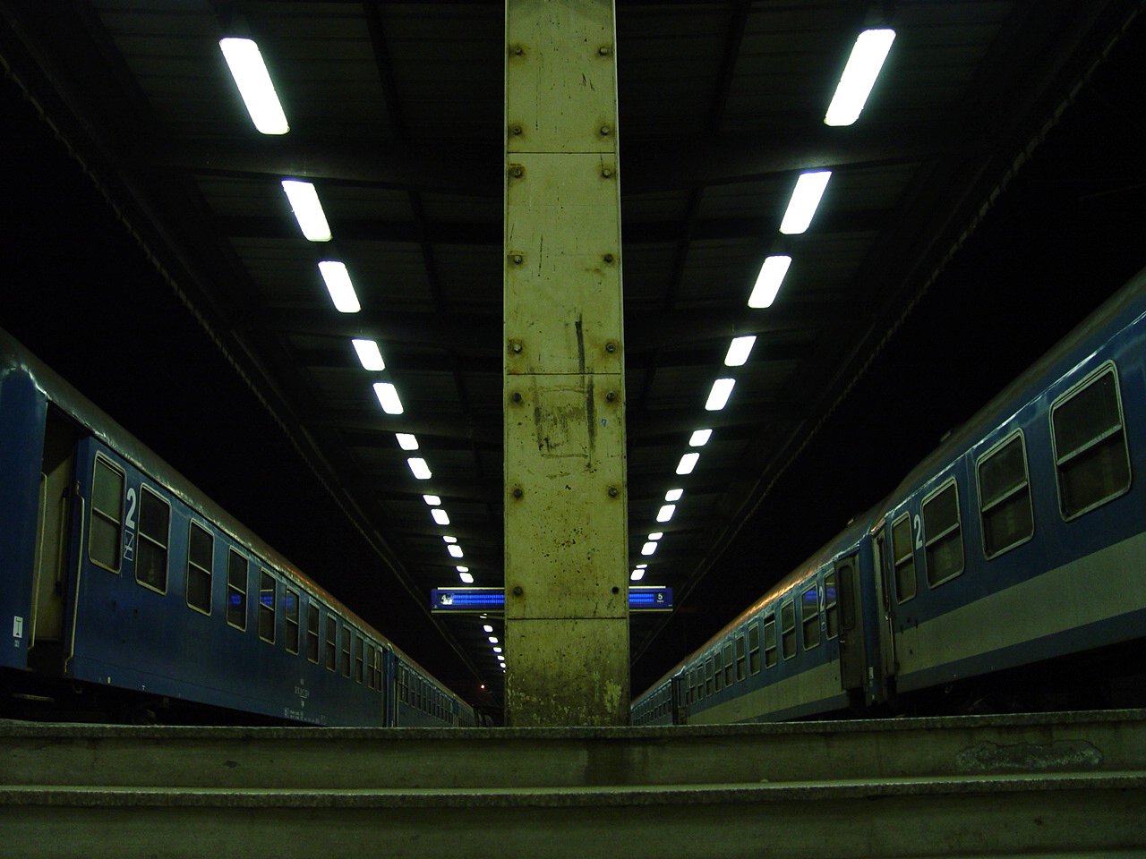 two trains passing by on train tracks in an underground area