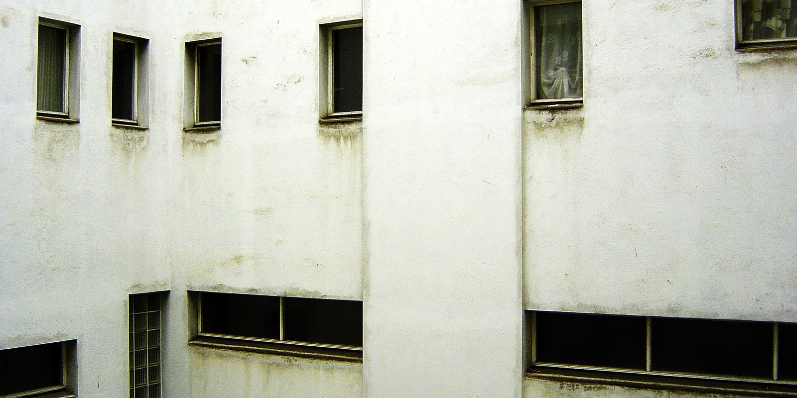 several windows and bars on a white building