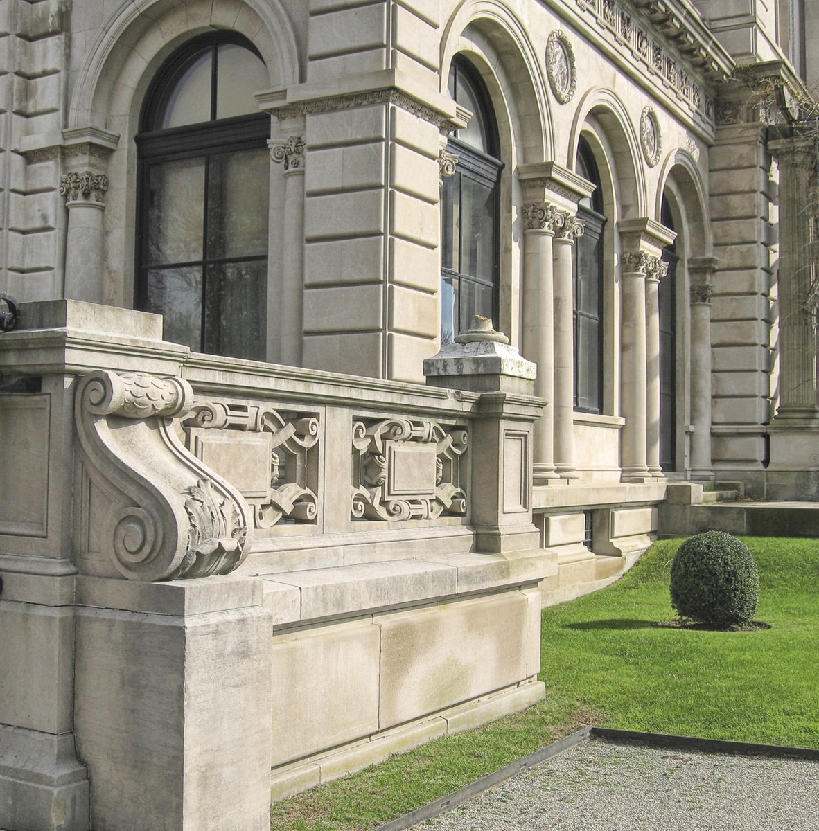 an ornate marble building with green grass around it