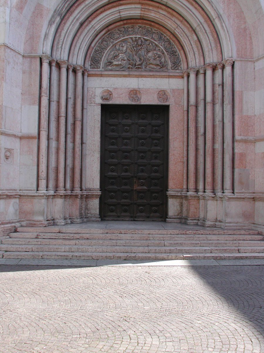 an arched door with ornate carvings on the side of an old building