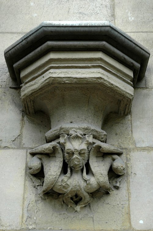 the ornate gargoyle of a building is carved into the corner