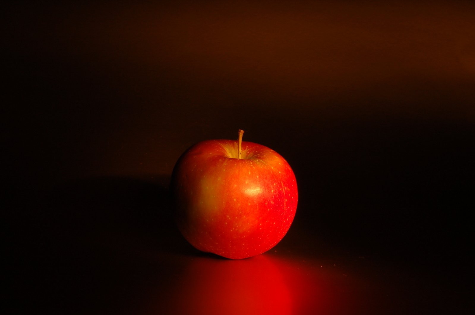 an apple sits on the table with the light coming in