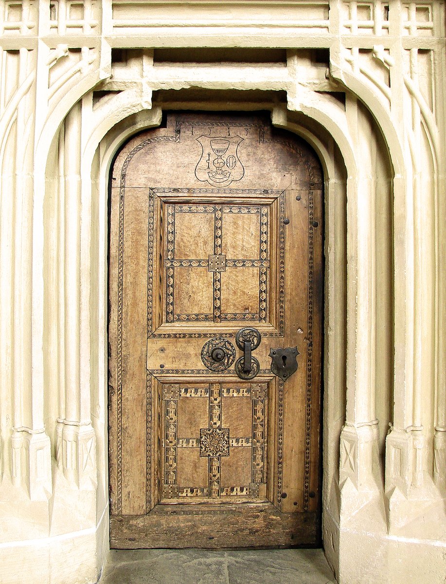 an ornate door sitting inside of a white building