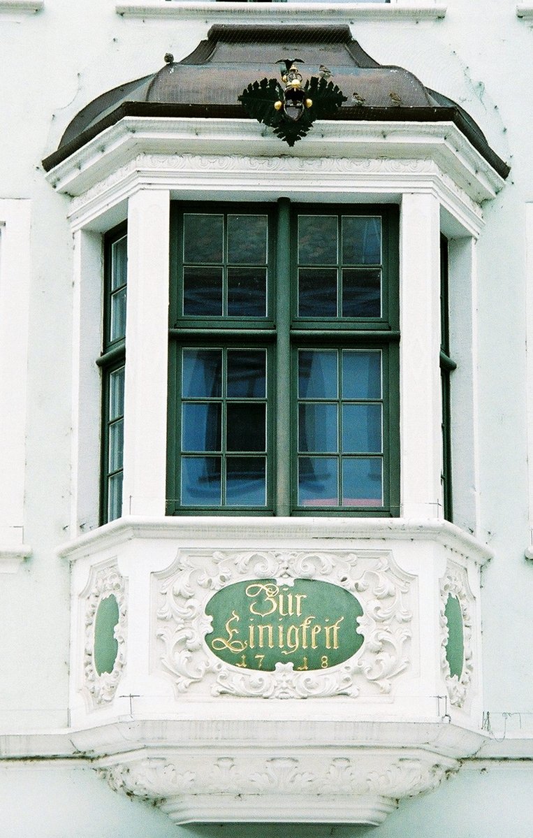 an ornate window and sign for an outside store