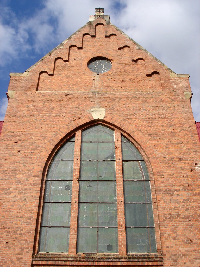 a red brick building has a church window