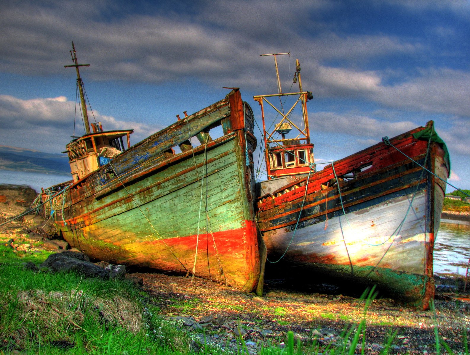 two large rusted and boarded up fishing vessels