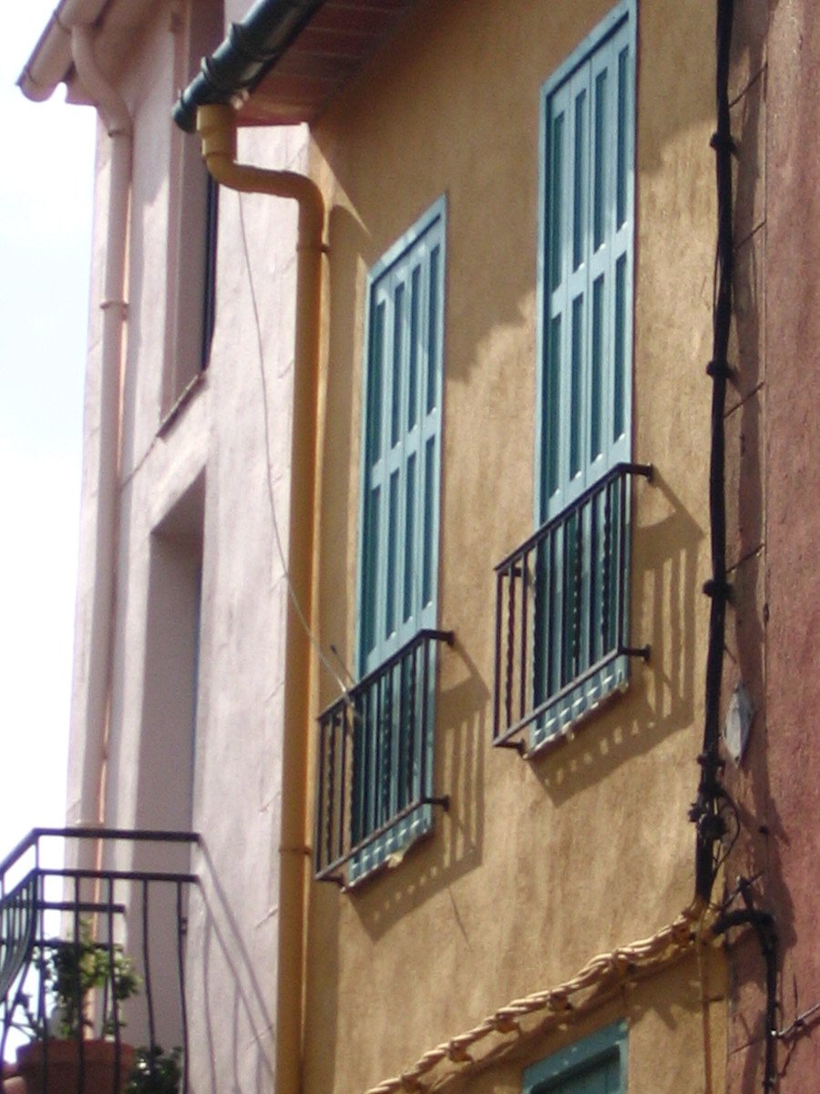 there are two windows and some balcony railings on the building