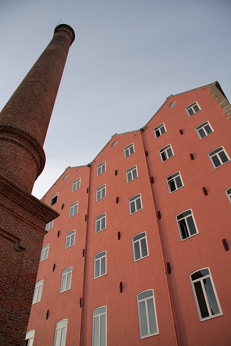 a tall brick building next to a stone column